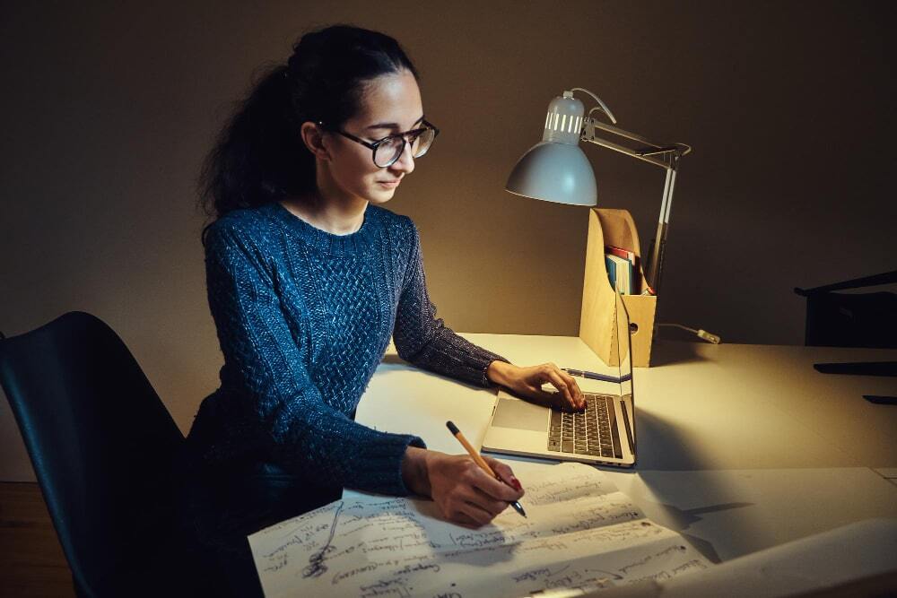(A female designer noting down all the important points for the signage board design) Designing for Visibility and Readability