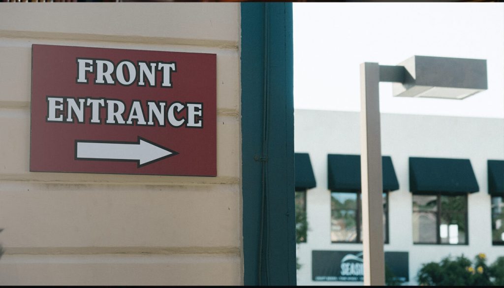 Sign indicating the front entrance of a building, featuring clear text for easy identification.